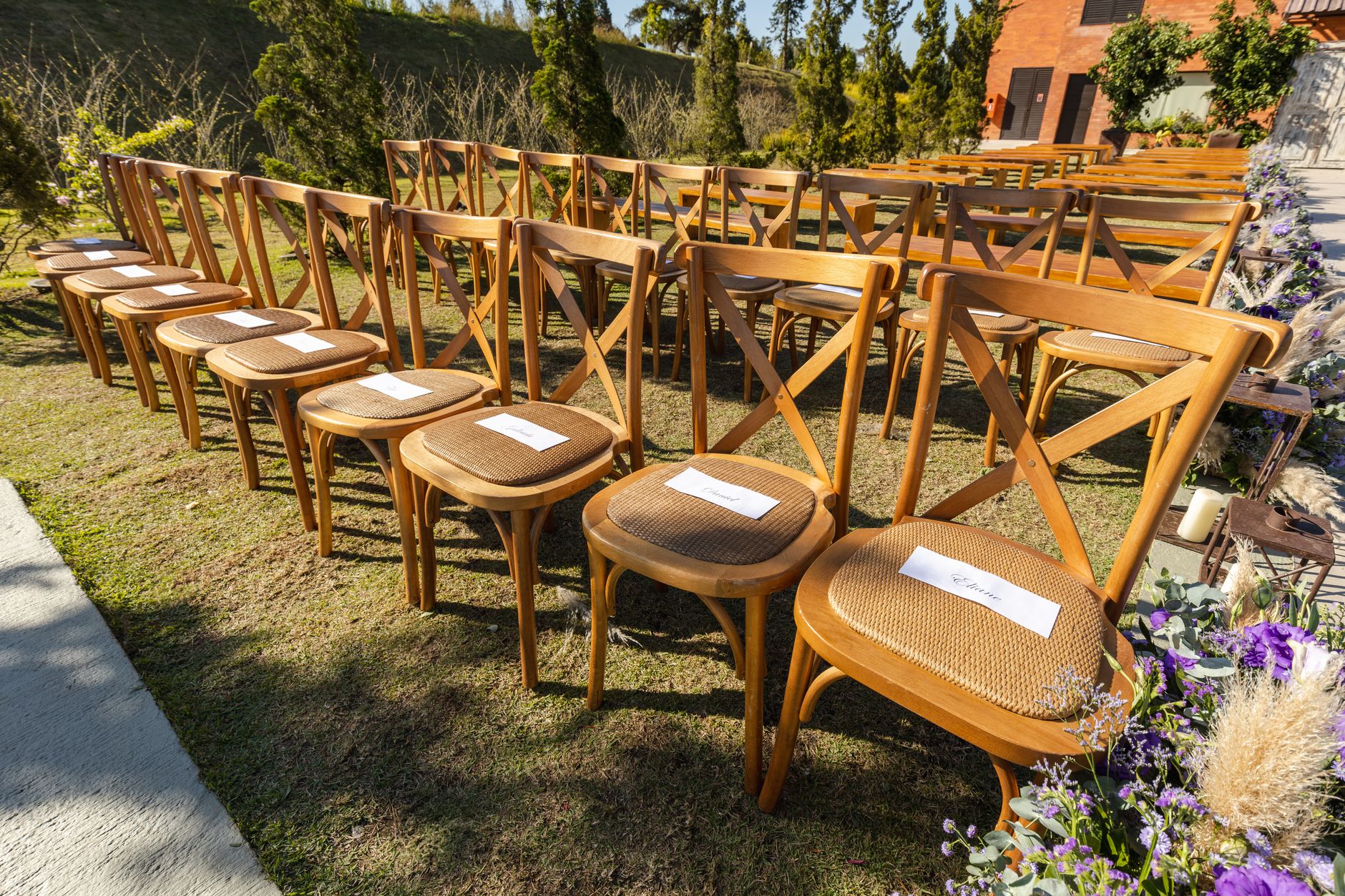 Rows of chairs lining a garden ceremony aisle