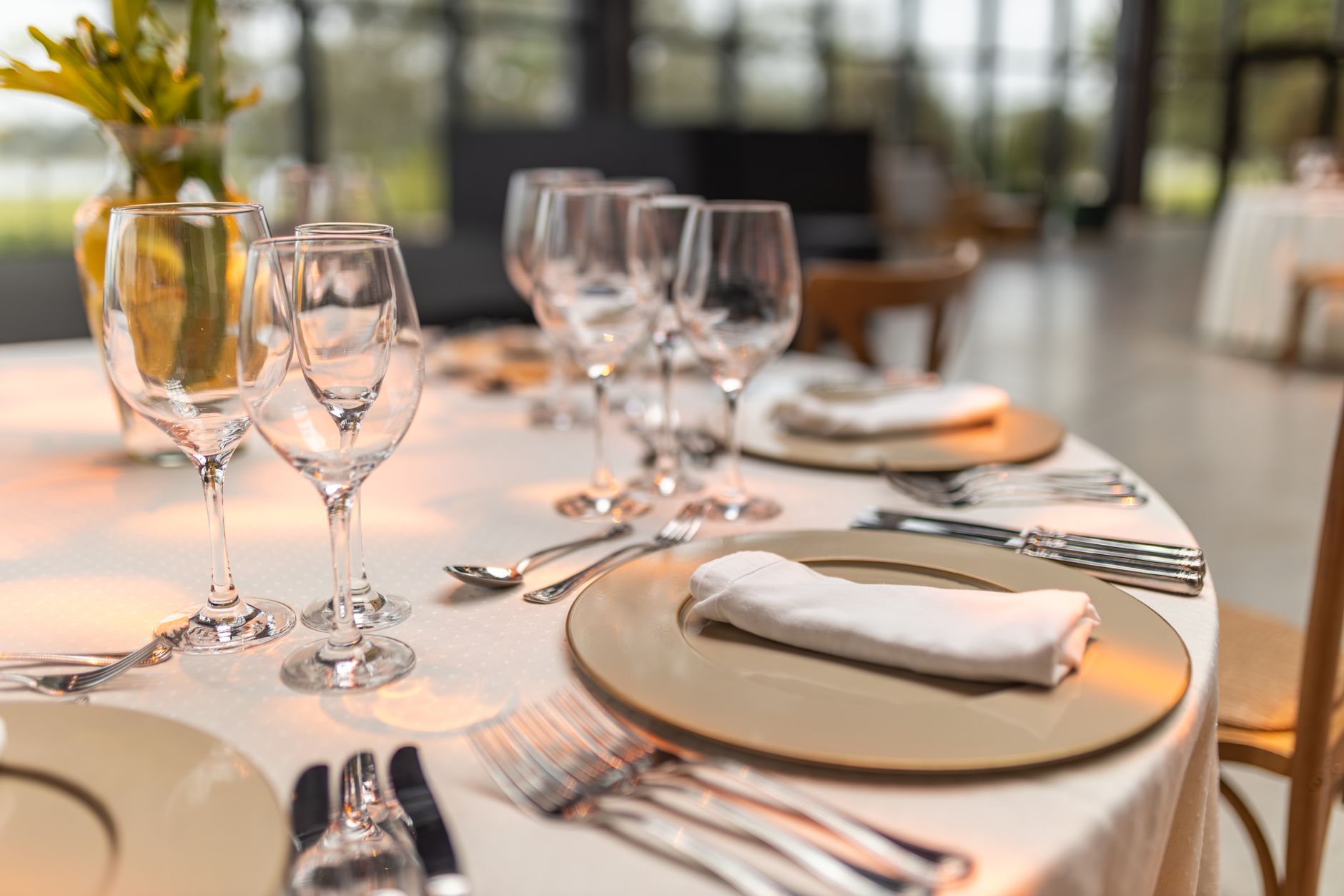 Brass flatware, charger plates and glassware at a place setting