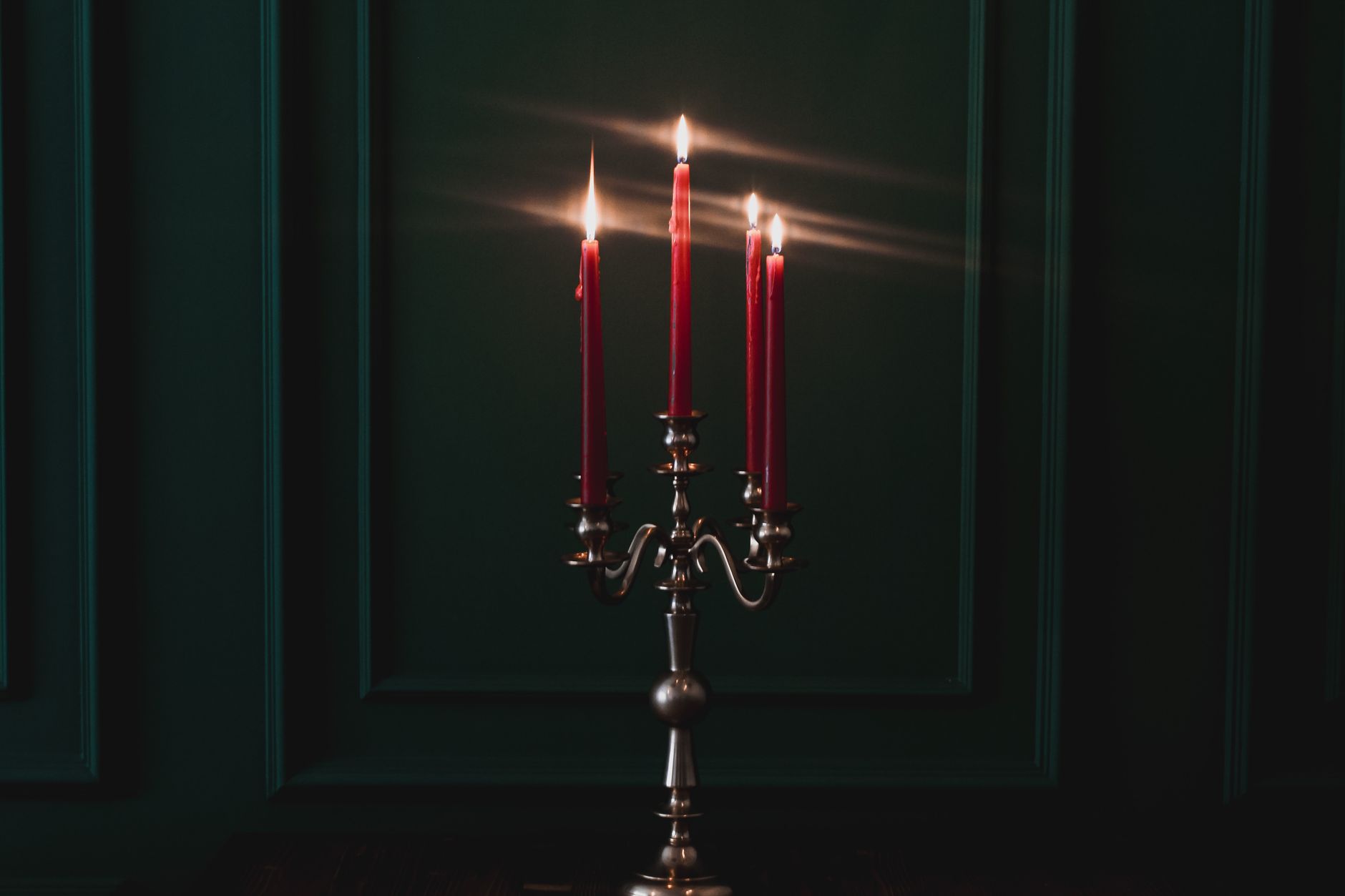 Tall candelabra holding lit taper candles